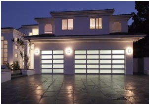 Aluminum garage doors on large home lit up at night