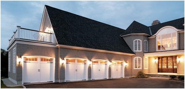 Four white garage doors on a large house