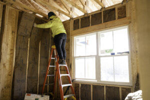Installing fiberglass batt insulation into a new construction building
